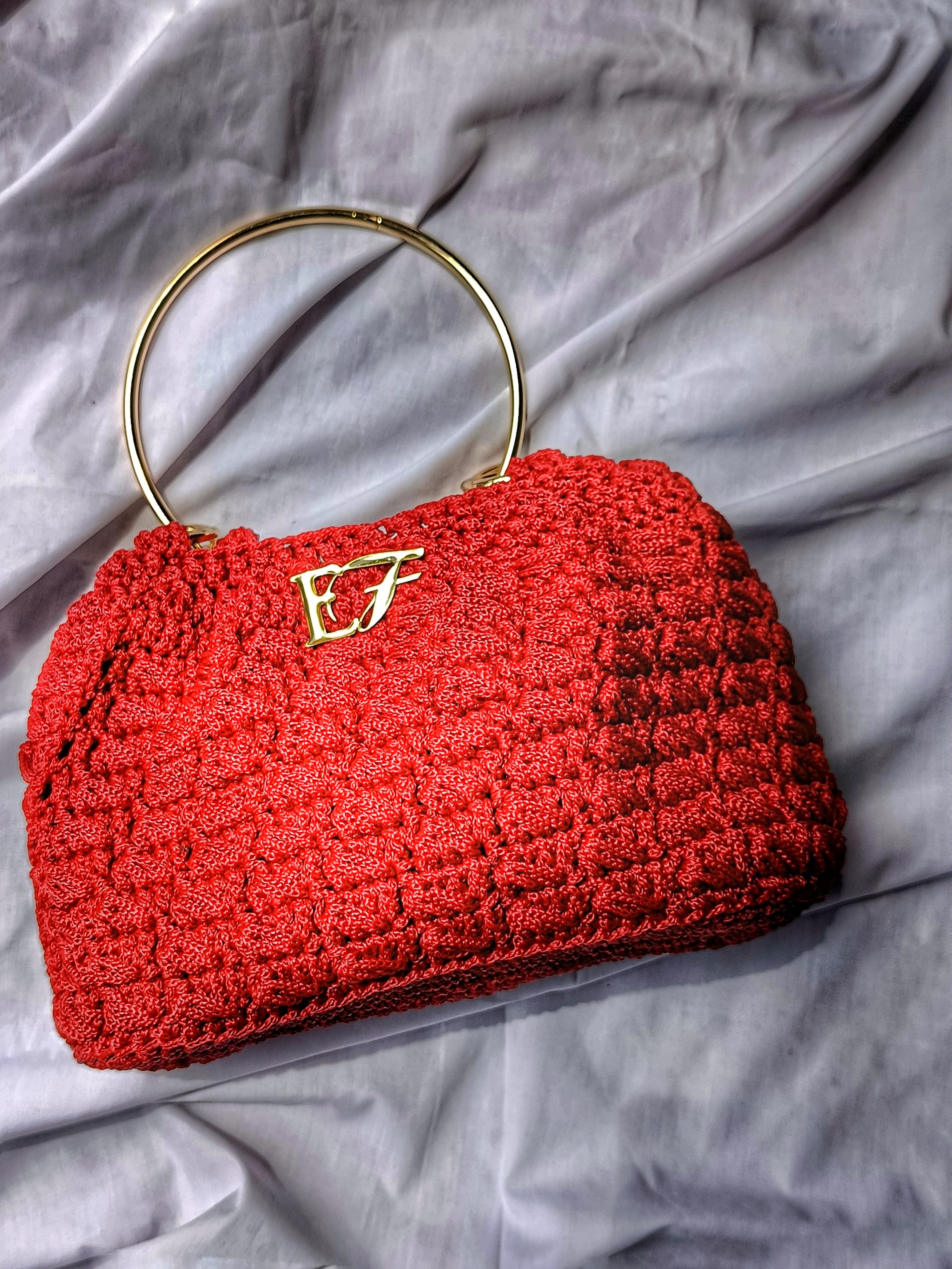 Ruby ring handle crochet handbag, angle view.